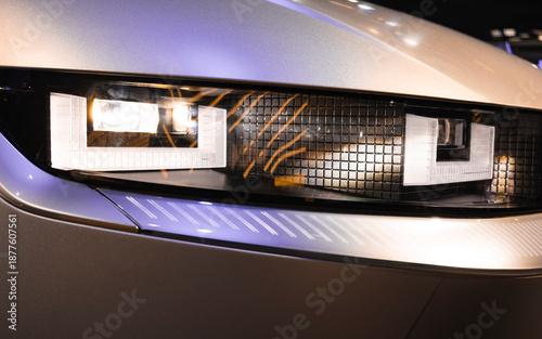 Close-up of an automotive LED headlight, featuring a modern rectangular design, precise lighting, and a sophisticated metallic finish.