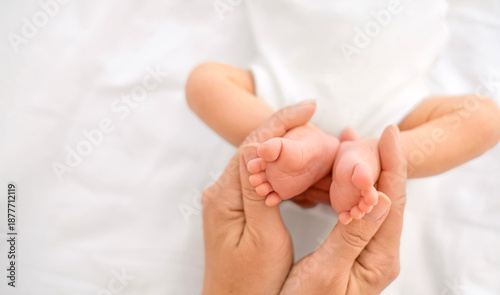 The small feet of a newborn baby , folded in the shape of a heart in the gentle hands of the mother