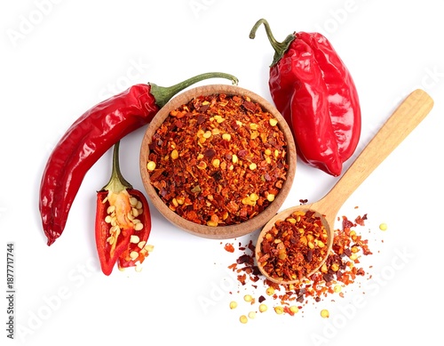 Overhead shot of various red peppers and flakes on a white background