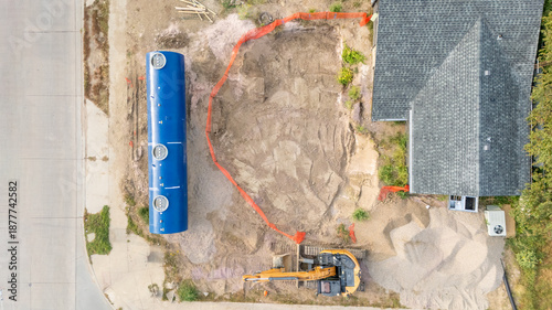 Aerial view of a construction site installing a new underground storage tank at a gas station.