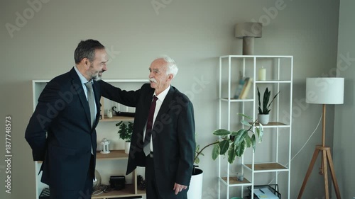 Father and Son Businessmen Discussing Succession in Modern Office – Senior and Middle Aged