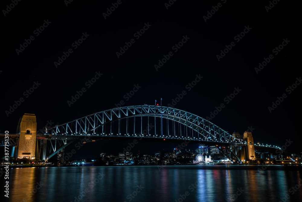 Fototapeta premium Paysage urbain au crépuscule avec une vue du port de Sydney et son pont illuminé