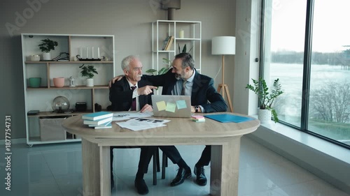 Father and Son Businessmen Celebrating Success at Computer in Modern Office – Senior and Middle Aged Businessmen