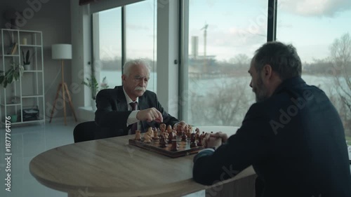 Middle Aged and Senior Businessmen Playing Chess in Office