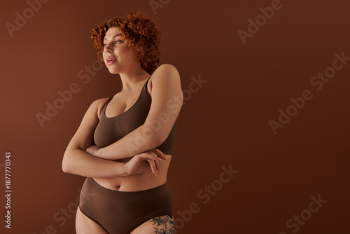 Fotografie Embracing curves and confidence in a warm-toned studio setting