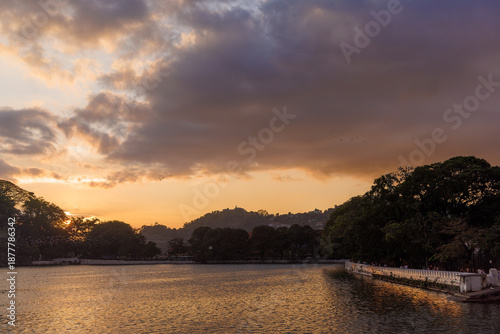Vászonkép Lake at Sunset with Birds Flying Over Calm Water in Kandy, Sri Lanka