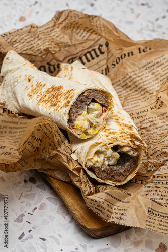doner kebab, shawarma is a shawarma with a filling of fresh vegetables and meat. with a lot of spices. served in a restaurant. on a dark background. for menus and advertisements