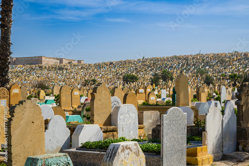 Vast cemetery landscape under a blue sky with numerous gravestones extending into the distance. Rabat, Morocco