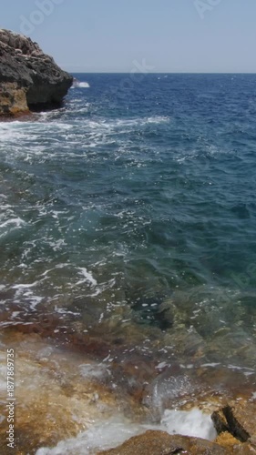 Boats with tourists vacationing near Malta's rocky coastline with clear water