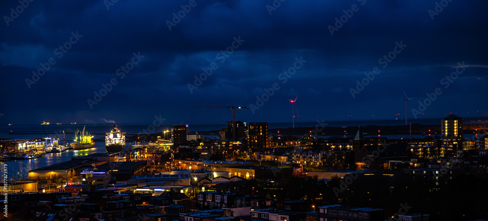 Obraz premium Ijmuiden Netherlands aerial view at night. Old dancing houses, canals, river channel and ships, canals with bridges, old european city landscape from above.