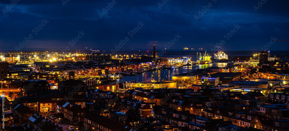 Fototapeta premium Ijmuiden Netherlands aerial view at night. Old dancing houses, canals, river channel and ships, canals with bridges, old european city landscape from above.