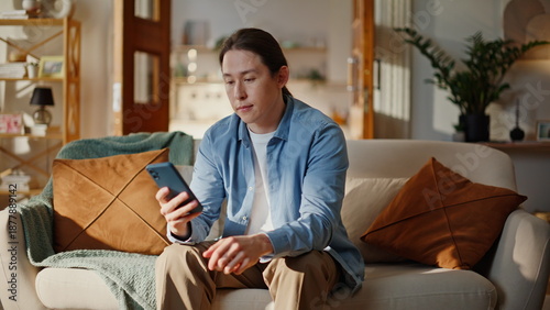 Excited hipster looking cellphone screen rejoicing online win at couch closeup