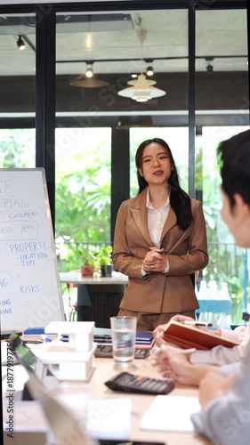 Young business woman executive ceo leader discussing project management planning strategy working with diverse colleagues company team at office corporate board group meeting.