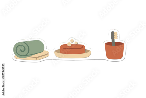 Rolled towel, soap, and toothbrush in a cup on a white surface