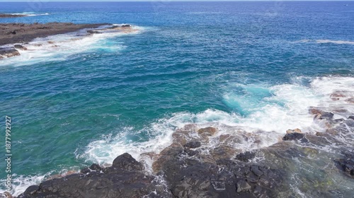 Wide aerial drone footage showing a volcanic coastline and open ocean in Cap La Houssaye Reunion Island. Ideal for travel establishing shots, documentary visuals, or neutral coastal backgrounds.