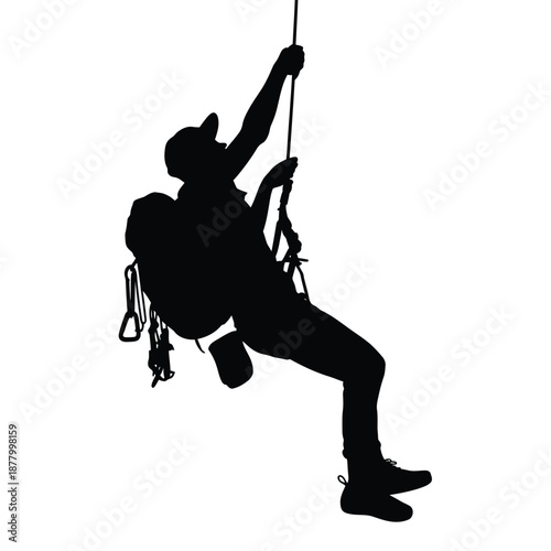 Silhouette of a rock climber rappelling down a steep rocky face