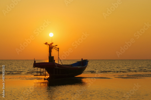 Fishing boats on the beach when the sun begins to set with a beautiful backdrop of sea and sand.