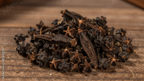 Wallpaper Mural Close-up of a pile of long pepper catkins with dark, textured pods on a rustic wooden table Torontodigital.ca