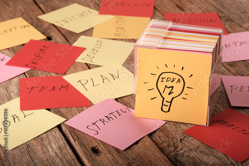 Bright idea box with cards displaying words related to planning and teamwork on a wooden table