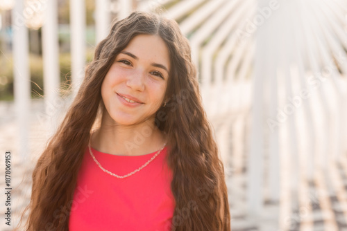 beautiful teenage brunette girl with long hair, smiling, looking at the camera during a summer walk Free Download beautiful teenage brunette girl with long hair, smiling, looking at the camera during a summer walk - GFXLoad
