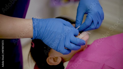 In a bright dental clinic, a young patient relaxes while wearing protective glasses.