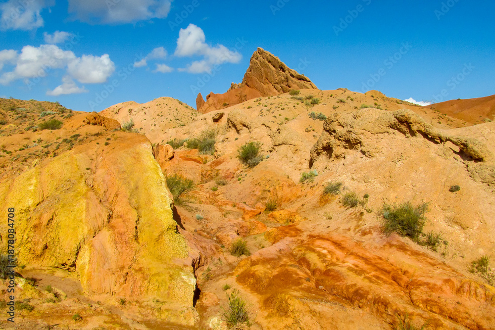 Fototapeta premium Colorful Fairytale canyon panorama landscape in Kyrgyzstan. Orange and yellow mountain valley Skazka canyon, rainbow mountain landscape all over the world in Pamir near Issyk Kul lake