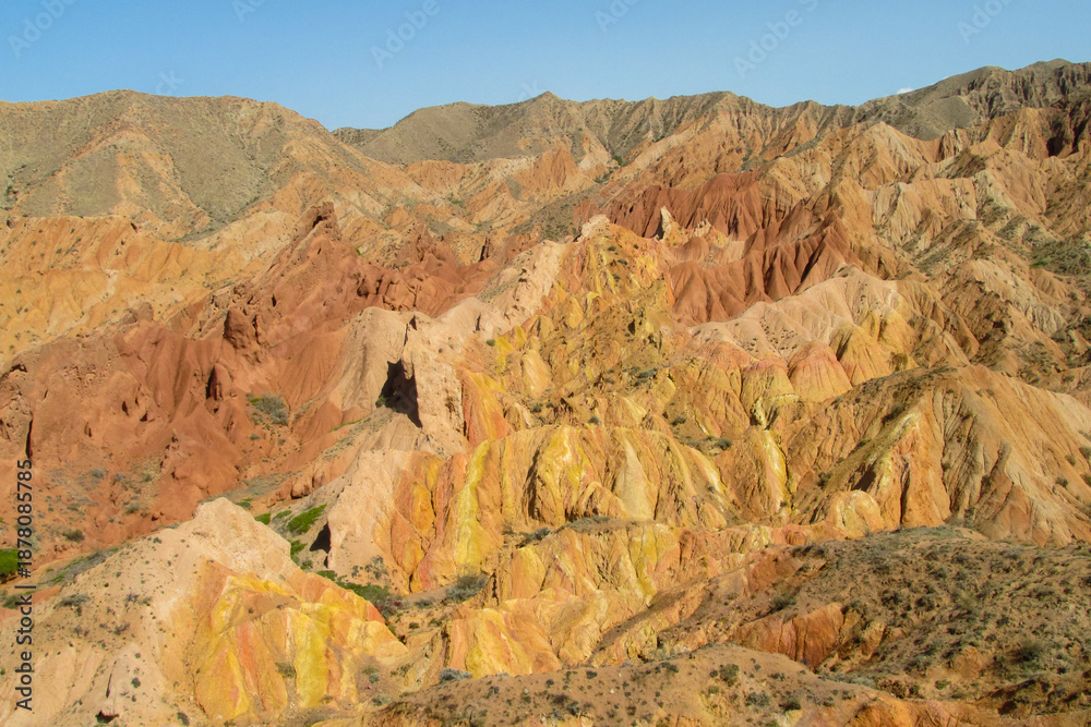 Fototapeta premium Colorful Fairytale canyon panorama landscape in Kyrgyzstan. Orange and yellow mountain valley Skazka canyon, rainbow mountain landscape all over the world in Pamir near Issyk Kul lake