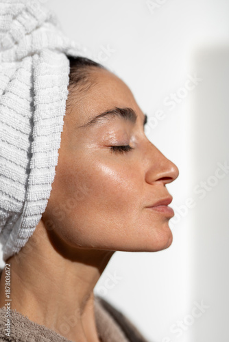 Canvas Print Side profile close-up of adult woman with towel wrapped hair and glowing skin, n
