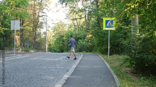 Wallpaper Mural A man steps off the sidewalk and crosses a quiet road surrounded by lush greenery, moving confidently across the street. The concept reflects motion, routine, lifestyle, and everyday urban activity Torontodigital.ca
