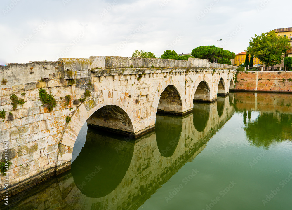 Obraz premium Tiberius Bridge over the river in Rimini. Italian classical architecture. A city landmark. Italy building