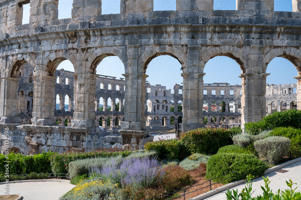 Obraz premium Part of the amphitheater and a planted walkway in Pula, Croatia