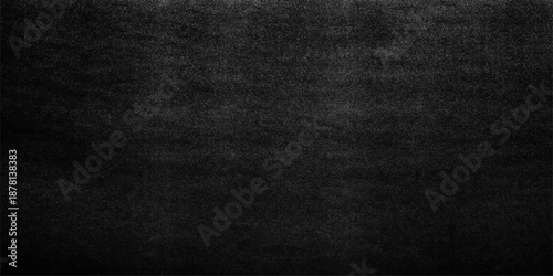 A closeup of a dark black leather and denim fabric textile with a rough grunge pattern on a textured material surface for a cloth wallpaper backdrop