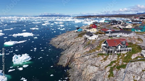 GREENLAND - 11.4.2025 - Amazing aerial footage moving up a colorful coastal Greenland village with ice floes in the water.