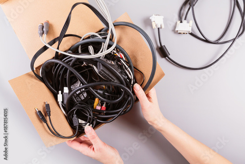 Konstfotografi Woman's hands packing outdated gadgets and cables into a recycling container, de