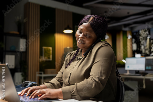 Businesswoman answering phone call for a remote discussion with associate, smiling as she joins a collaborative chat on telephone line. Adaptability and attentiveness for professional connection.