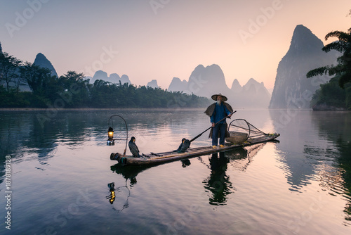 Old chinese fisherman at sunrise on the Li river, China