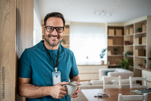 Quadro em tela Male doctor or nurse smiling and holding coffee cup