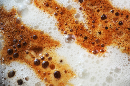 Pouring black coffee on milk froth