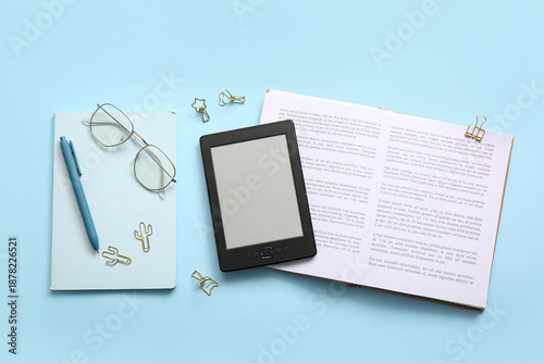 Tablou pe pânză Modern e-reader with book, notebook and eyeglasses on blue background