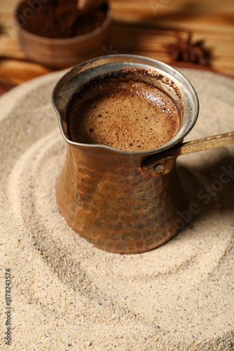 Cezve with coffee in sand o...