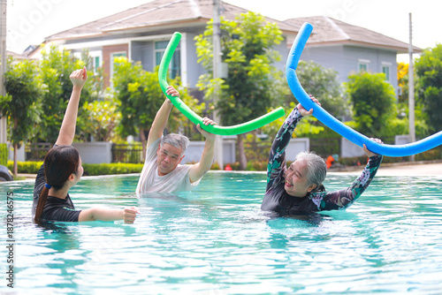 Health center staff teach elderly exercises to help them recover in the water while in an outdoor pool. Hydrotherapy concept. Health care.