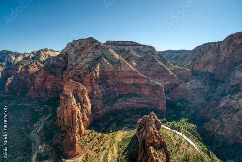 The mountains are covered in red and brown rocks. The sky is clear and blue. The mountains are very tall and steep
