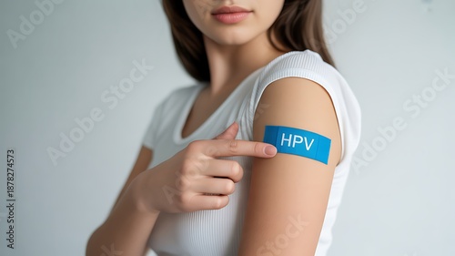 Woman pointing to a blue band on her arm indicating an HPV vaccination