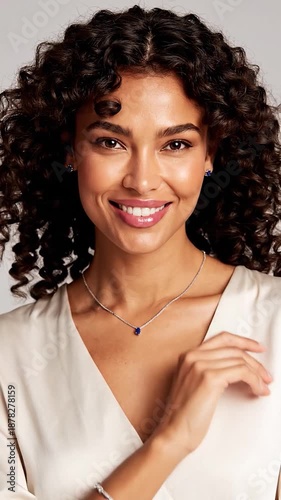 Smiling woman with curly hair and diamond jewelry
