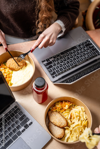 People eating takeaway lunch while working
