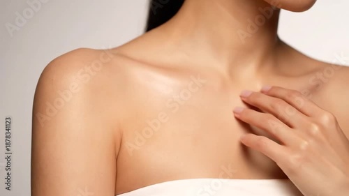 Close-up of a person's smooth shoulder and arm with fingertips gently touching the skin