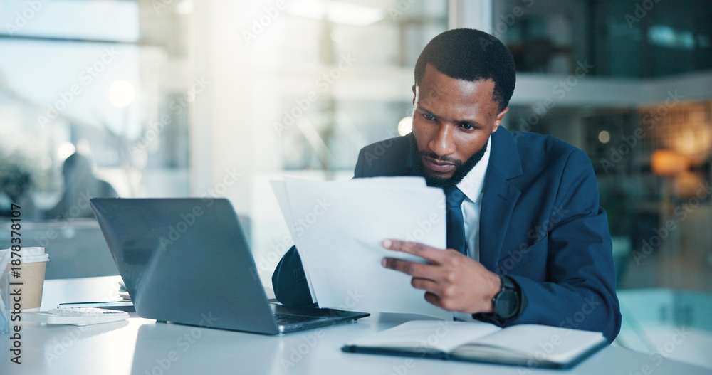 Obraz premium Investor, laptop and black man with documents, reading and checklist for company audit. African person, trading strategy and financial advisor in office, pc and research for stock market and planning