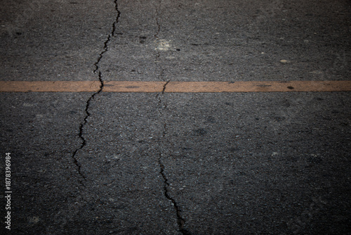 Detailed close-up of a damaged road surface with visible cracks and rough texture.