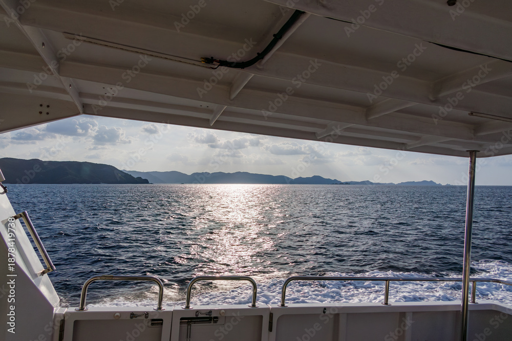 Obraz premium 周囲の島々を繋ぐ、村営連絡船「みつしま」。 沖には多くの無人島が浮かんでいる。 座間味港 座間味島沖縄県島尻郡慶良間諸島-2025 沖縄本島から40km西方にある諸島。 大小30以上の島々からなる島嶼群は全体が国立公園に指定されている。 珊瑚礁の海、白い砂浜、緑の山地は世界屈指の美しさ。 多くの貴重な動植物が生息している。 