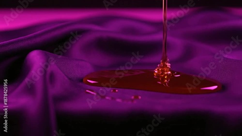 Red Liquid Pouring onto Purple Fabric.